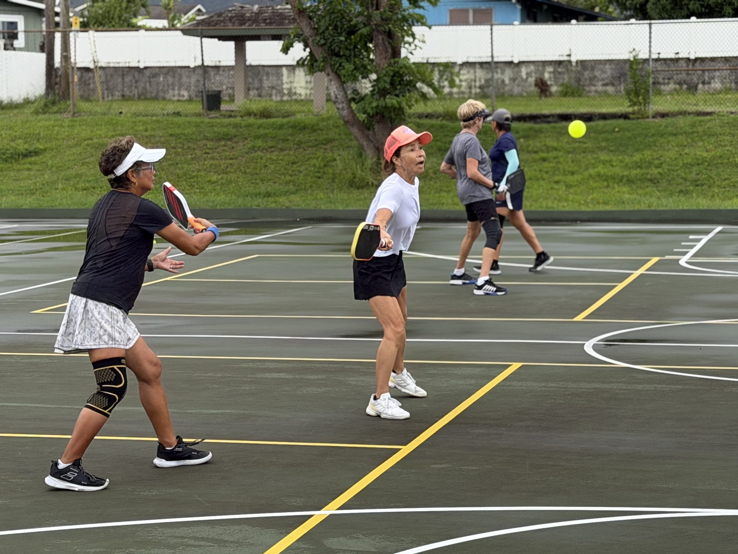 Pickleball players competing during a point in Honolulu, Hawaii